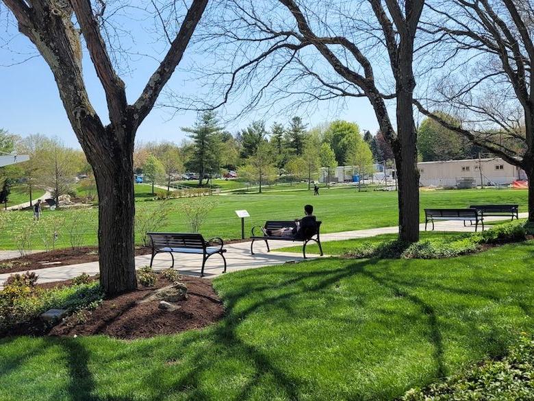 A student relaxes on a bench outside Perkins Student Center